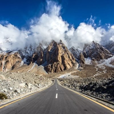 Karakoram Highway winding through rugged mountains with valleys and rivers below.