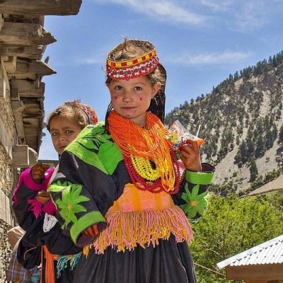 Kalash men and women in colorful traditional dresses during a cultural festival.